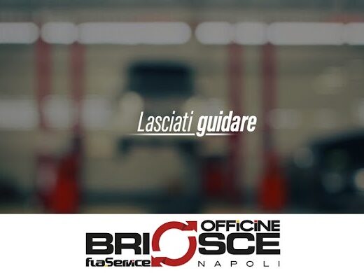 Interno di Officine Briosce a Napoli, con auto sollevata su ponte e scritta "Lasciati guidare", servizio assistenza e riparazione moto