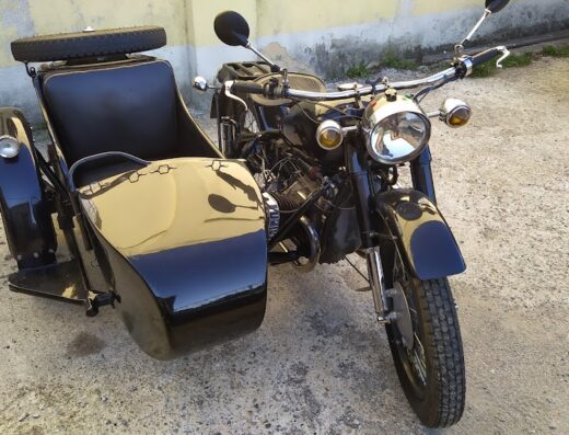 Moto d'epoca nera con sidecar, ideale per restauro o riparazione. Scooter classico per appassionati di viaggi e accessori vintage.