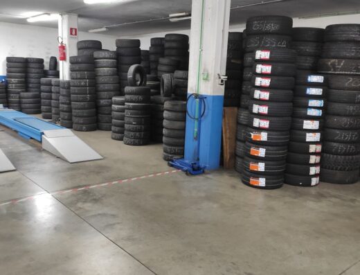 Immagine di un magazzino di Orazio Gomme con pile di pneumatici per moto, accessori e servizi di manutenzione.