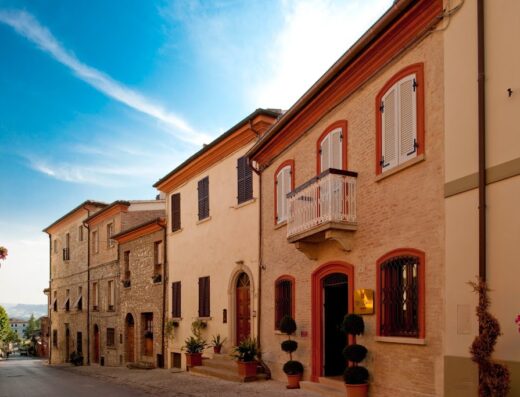 Strada panoramica con edifici storici a Oste del Castello, un wellness bike hotel ideale per cicloturismo e vacanze rilassanti.