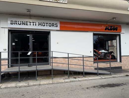 Foto della concessionaria Brunetti Motors, rivenditore autorizzato KTM. In vetrina si intravede una moto KTM. Ottobielle S.R.L.
