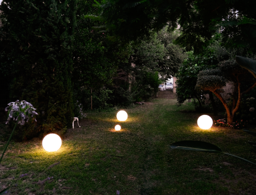Giardino illuminato di sera al Palazzo Murat Luxury Rooms, con sfere luminose sul prato che guidano verso la scalinata.