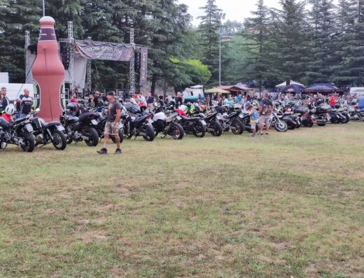 Parco dell'Annunziata affollato di motociclette e persone durante un evento biker, con palco e stand visibili sullo sfondo.