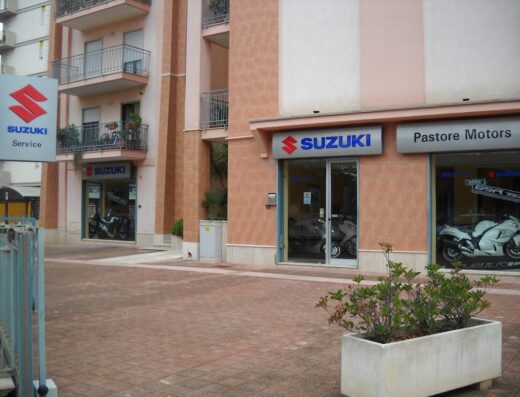 Pastore Motors concessionaria Suzuki: vetrine espositive con moto Suzuki in vendita e insegna del servizio assistenza.