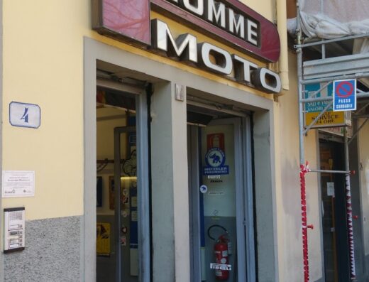 Ingresso di Pecchioli Gomme S.A.S. Driver Center Pirelli a Firenze, specializzato in pneumatici e servizi per moto. Insegna "Gomme Moto" ben visibile sopra l'entrata.