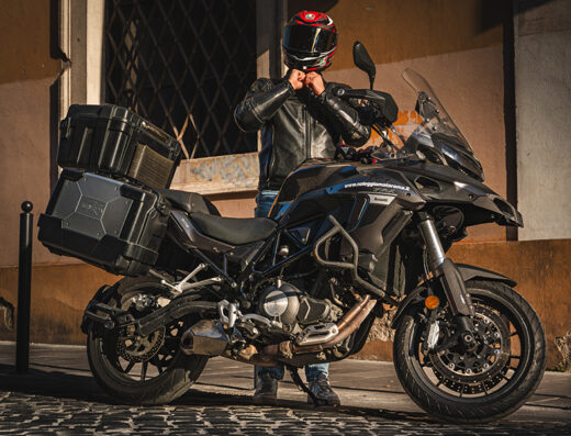 Noleggio moto Benelli TRK 502 X con accessori travel, bauletti rigidi e rider con casco, ideale per tour e viaggi su strada.