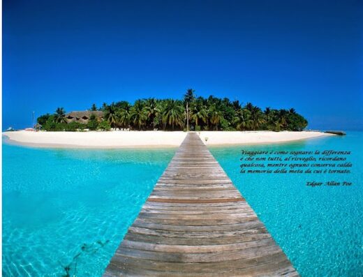 Isola tropicale con spiaggia bianca e mare turchese, raggiungibile tramite un lungo pontile in legno, ideale per viaggi e vacanze da sogno con Piellemme Viaggi.