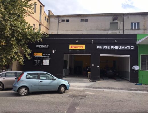 Piesse Pneumatici SRL Driver Center Pirelli Alba Adriatica: vista esterna dell'officina con auto parcheggiate di fronte e insegne ben visibili.