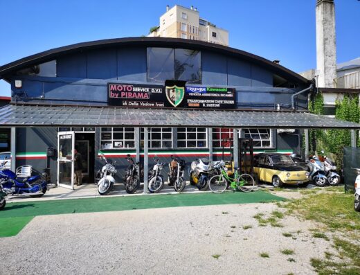 Pirama di Delle Vedove Ivan: Facciata dell'officina moto con esposizione di motociclette Triumph, Kawasaki, moto custom e vendita accessori e ricambi.