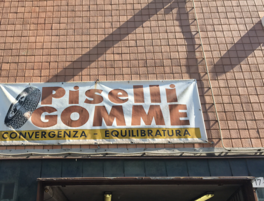 Insegna di Piselli Gomme, officina specializzata in pneumatici per moto e auto, con servizi di convergenza ed equilibratura.