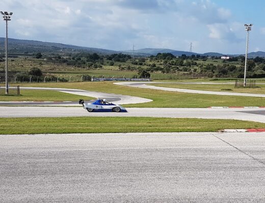 Auto da corsa monoposto bianca e blu numero 94 in pista al Pista del Sole, circuito automobilistico con sfondo collinare.