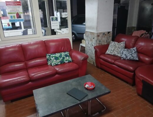 Sala d'attesa con divani in pelle rossa e tavolino, parte dell'arredamento di Polverino Vincenzo, location per la vendita di moto e accessori.