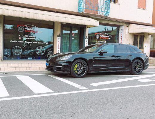 Porsche Panamera nera di fronte al negozio Premium Wheels HD, specializzato in cerchi e gomme nuove e usate, con sensori TPMS.