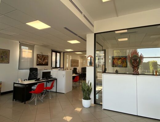 Uffici moderni e luminosi di Proviaggi, con scrivanie, sedie rosse, e decorazioni artistiche per un'esperienza di viaggio personalizzata.