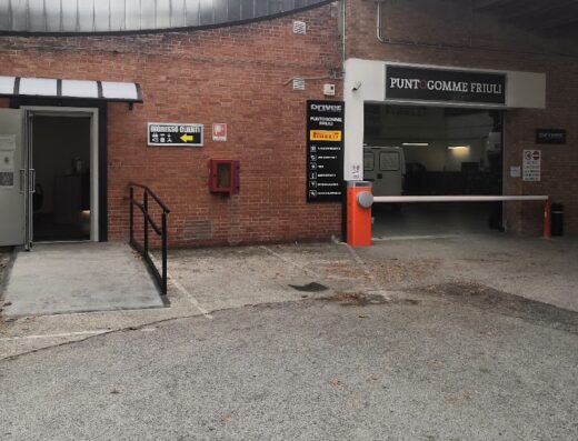 Puntogomme Friuli Srl Driver Center Pirelli: Esterno dell'officina con ingresso clienti e area di servizio pneumatici per moto e auto.