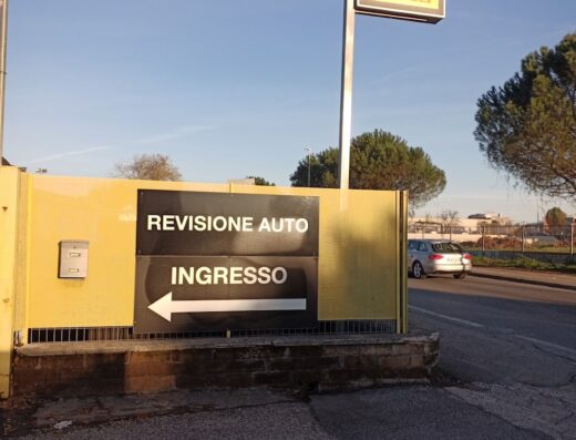Cartello stradale di PUNTOGOMME LAZIO SRL Driver Center Pirelli a Roma, indicazioni per la revisione auto e l'ingresso.