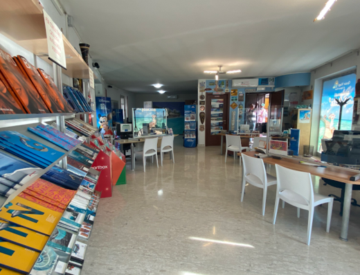 Interno luminoso di Quasar Viaggi di Vigliotti Mattia, agenzia viaggi con scaffali di cataloghi turistici, scrivanie e computer.