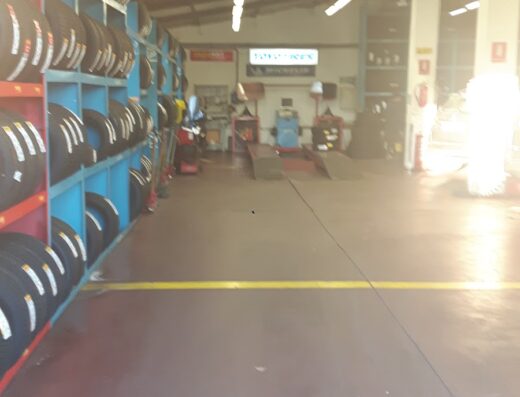 Interno di Redi Gomme srl: scaffali pieni di pneumatici per moto e auto, attrezzature per la riparazione e sostituzione gomme.