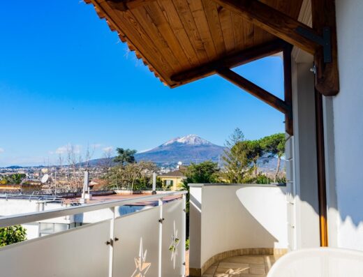Vista dal balcone del Relais Country House Pompei Apartments con il Vesuvio innevato sullo sfondo, un'oasi di relax e comfort.