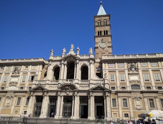 Facciata principale della Basilica di Santa Maria Maggiore a Roma, con la sua imponente torre campanaria e dettagli architettonici barocchi.