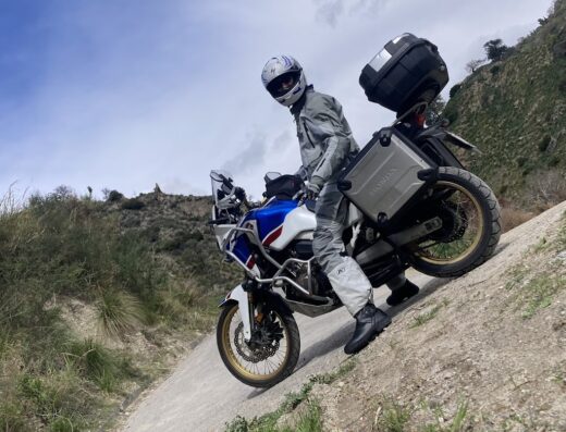 Pilota su moto Honda Africa Twin in Sicilia. Noleggio moto adventure per esplorare le strade e i paesaggi siciliani con accessori come bauletto e valigie laterali.