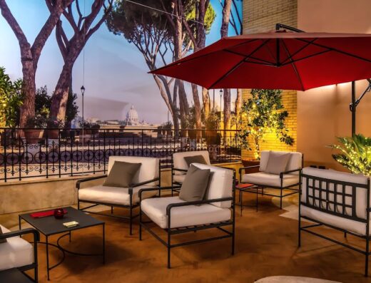 Terrazza panoramica dell'hotel River Chateau con vista su Roma, arredata con divani e poltrone per il relax degli ospiti.