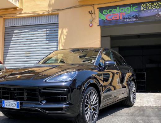 Auto nera di lusso parcheggiata davanti all'autolavaggio ecologico S.P. Service Auto, con targa italiana ben visibile.