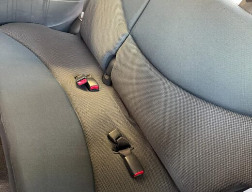 Dettaglio dei sedili posteriori di un'auto dopo il servizio di sanificazione e lavaggio interni a Torino, evidenziando la pulizia e l'igiene dei tessuti.