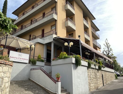 Hotel Santa Caterina & Bike: vista esterna dell'hotel con ingresso, insegna e dettagli architettonici. Ideale per viaggi in moto e relax.