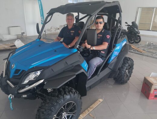 Due agenti della Polizia Locale a bordo di un quad CFMOTO blu e nero, un veicolo ideale per il controllo del territorio e la sicurezza stradale offerto da Sanza Motors, officina specializzata in moto e minicar.