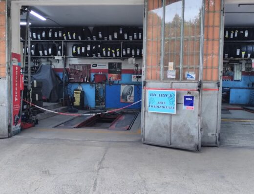 Ingresso di Sauro Gomme Pneumatici, officina specializzata in pneumatici per moto e auto con scaffali di gomme, attrezzatura e ponte sollevatore.