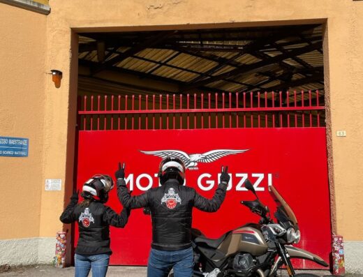 Due motociclisti posano davanti a una Moto Guzzi presso la concessionaria Scarabel Holding Aprilia e Moto Guzzi.