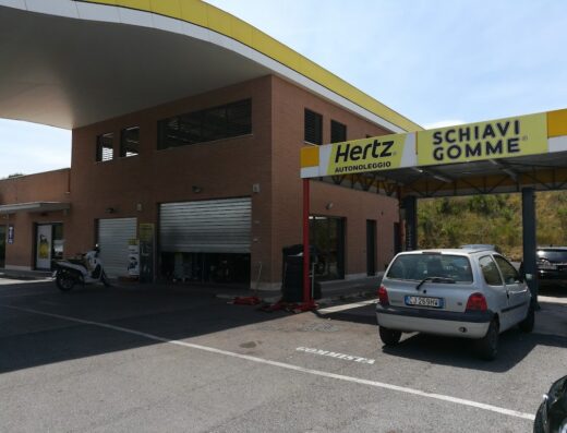 Schiavi Gomme a Via Borghesiana, officina riparazione moto e auto, servizio cambio gomme e vendita accessori moto, scooter parcheggiato all'esterno, area Hertz autonoleggio.