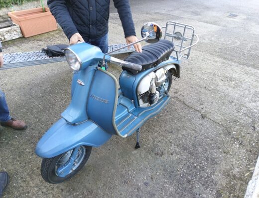 Scooter italiano Lambretta d'epoca di colore azzurro con portapacchi, ideale per il restauro, il collezionismo o da usare come mezzo di trasporto urbano.