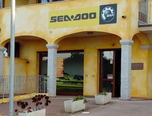 Seadoo Centre Sardinia: Vista esterna del negozio con insegna Sea-Doo e moto d'acqua visibile all'interno. Vendita e assistenza Sea-Doo a Sardinia.