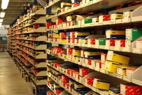 Scaffali pieni di scatole di ricambi e accessori per moto presso Sericambi, fornitore di ricambi per motocicli e servizi per motociclisti.