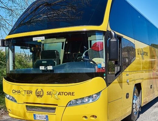 Autobus giallo di Serratore Viaggi e Turismo, azienda specializzata in charter tour e servizi di trasporto passeggeri per viaggi e vacanze.