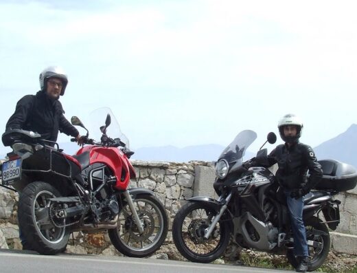 Due motociclisti in sella alle loro moto da turismo, una rossa e una nera, durante un tour in Sicilia con Sicily Moto Rent di S. D. M.