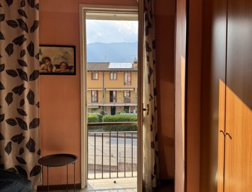 Interno di una camera del Sleep Well Motel con vista sul balcone, arredamento accogliente, ideale per un soggiorno rilassante.