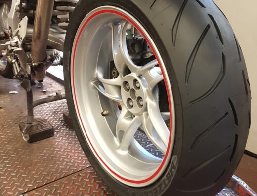 Primo piano di pneumatico Metzeler su moto presso Speedy Gomme Snc: dettaglio del battistrada e cerchio in lega, ideale per viaggi e sicurezza stradale.