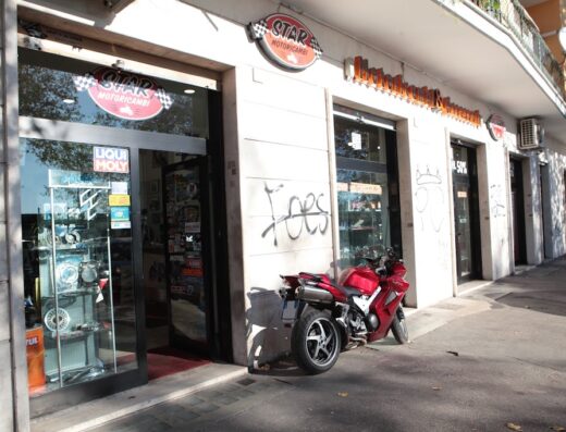 Star Motoricambi: facciata del negozio di ricambi moto e accessori con una moto rossa parcheggiata davanti, vetrine con prodotti esposti.