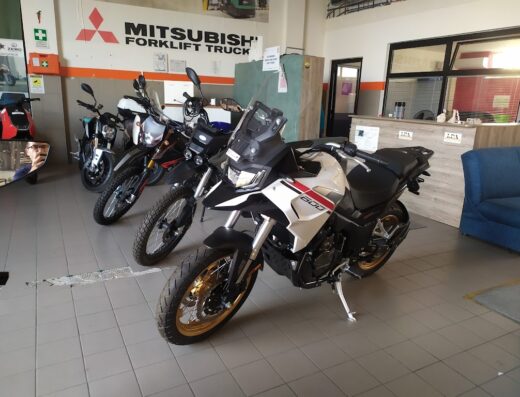 Concessionaria Greenmobilitsud: esposizione di moto, inclusa una adventure bike 500 bianca e nera con dettagli rossi, ideale per viaggi e avventure.