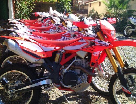 File di moto da enduro Beta rosse, pronte per il noleggio raid Sud Est. Accessori e moto per esplorare il territorio.