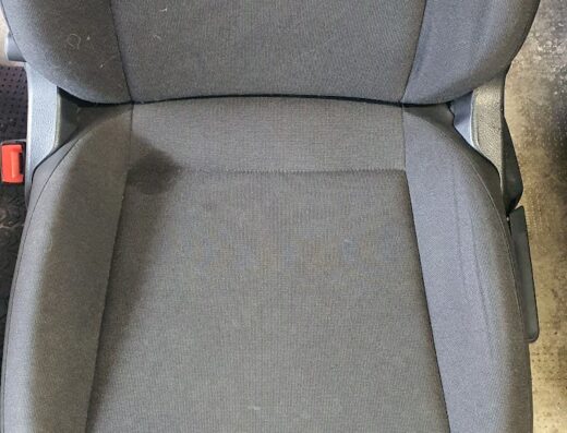 Primo piano del sedile di un'auto grigio dopo il servizio di detailing auto SuxCar, che mostra la pulizia e la cura degli interni.