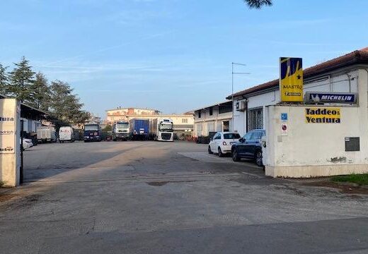 Esterno della sede di Taddeo & Ventura SRL, Mastro Michelin, con insegne dei marchi trattati. Parcheggio con auto e camion visibili.