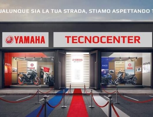 Tecnocenter Concessionario Ufficiale Yamaha: vista esterna del negozio con moto esposte, tappeto rosso e cartelli Yamaha, ideale per appassionati di moto e accessori
