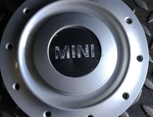 Coprimozzo Mini color argento con logo "MINI" nero al centro, accessorio auto per personalizzare il look del veicolo.