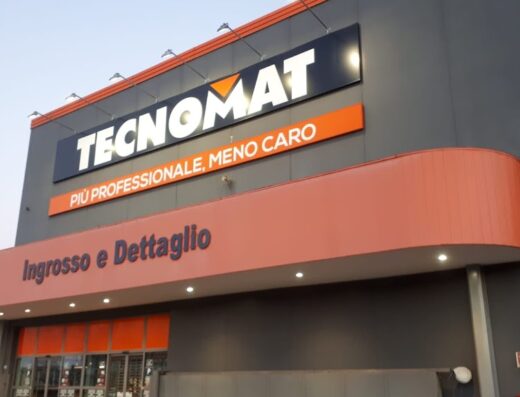 Esterno del negozio Tecnomat con insegna ben visibile, che evidenzia la scritta "Più professionale, meno caro" e l'indicazione per l'ingresso.