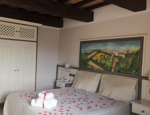 Camera matrimoniale decorata con petali di rosa e asciugamani bianchi, pronta per eventi romantici a Tenuta D'Ausilio, miglior hotel 4 stelle a Vairano Patenora, Caianello.