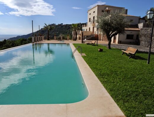 Piscina panoramica presso Tenuta Santa Tecla, un incantevole hotel in una fattoria siciliana con vista sul mare.